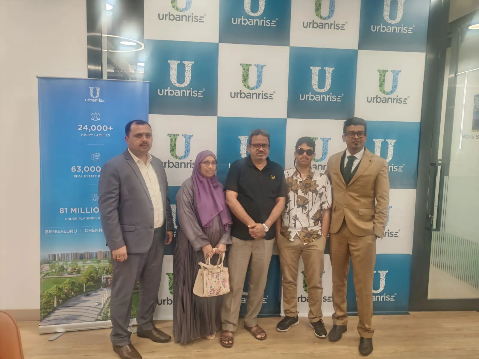 A family photographed with Urbanrise representatives at the Prelaunch Utsav backdrop