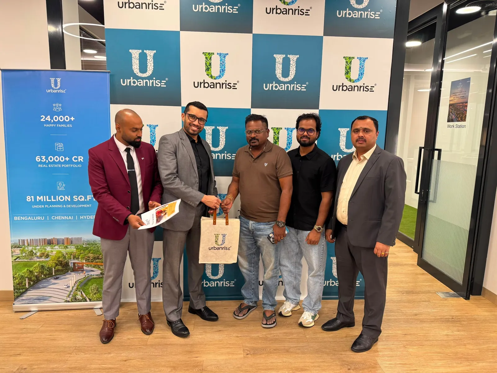 A buyer receiving an Urbanrise jute bag from the team at the Utsav backdrop