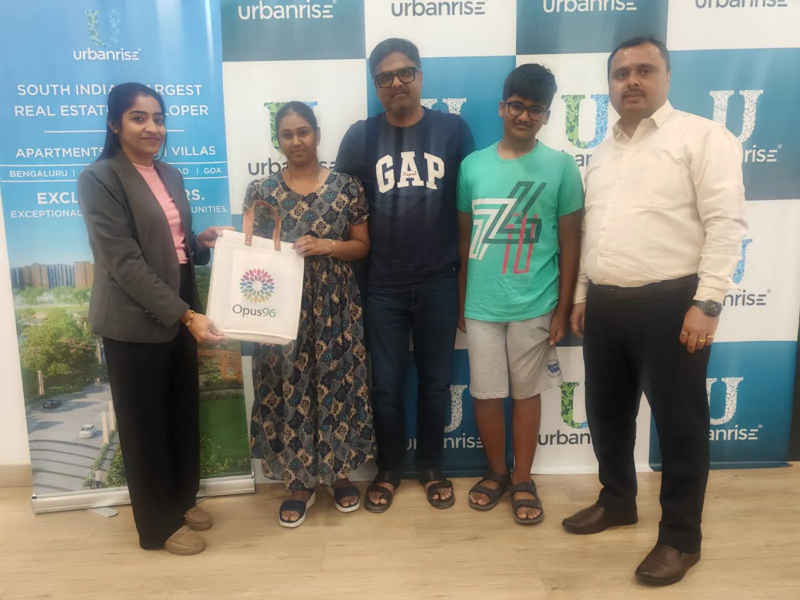 A family holding their Opus 96 welcome bag with an Urbanrise representative