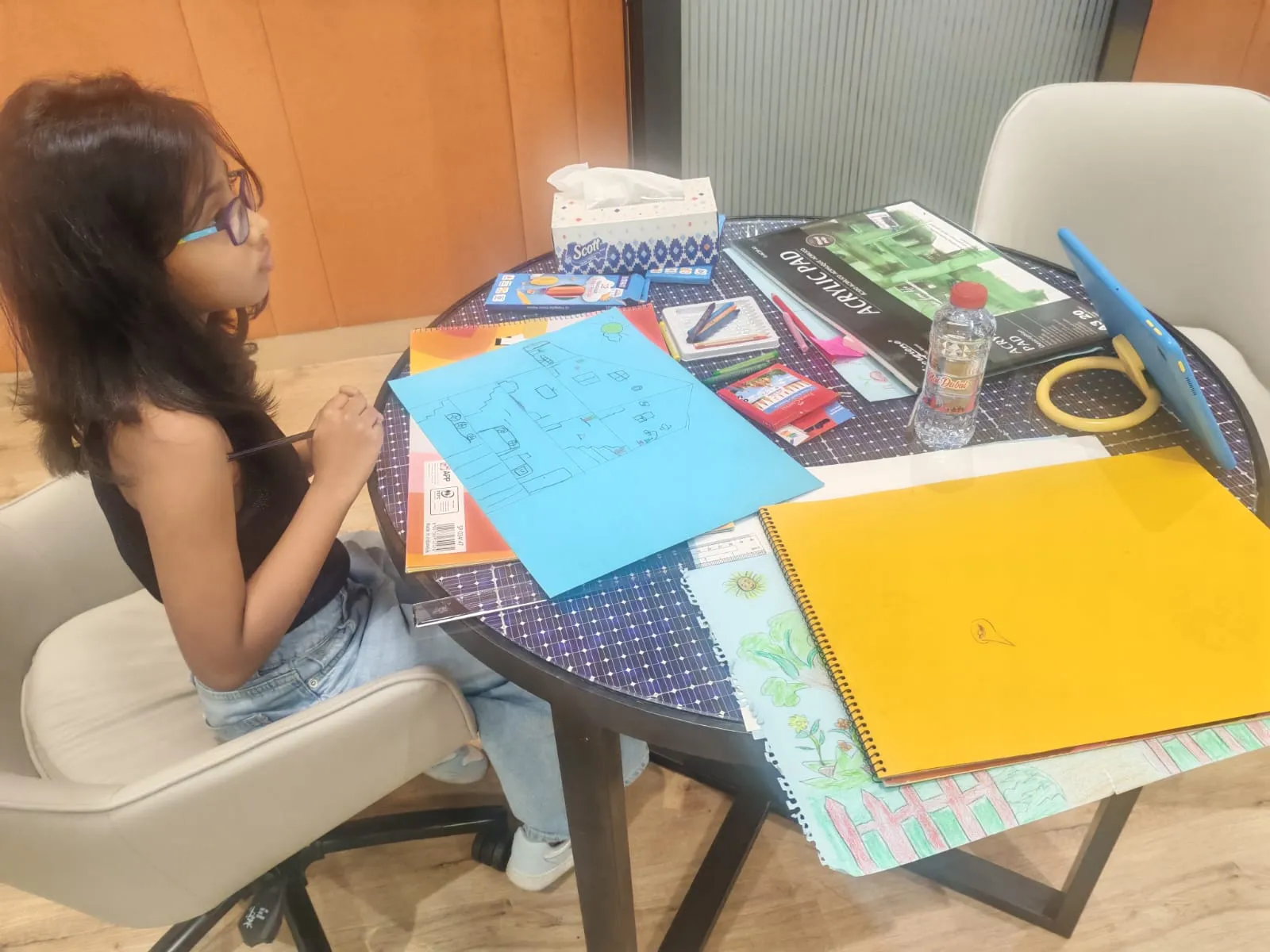 A child drawing at the kids' zone table